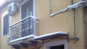 A yellow building with a balcony, a door, and a window. - Don Diego (Linguaglossa)