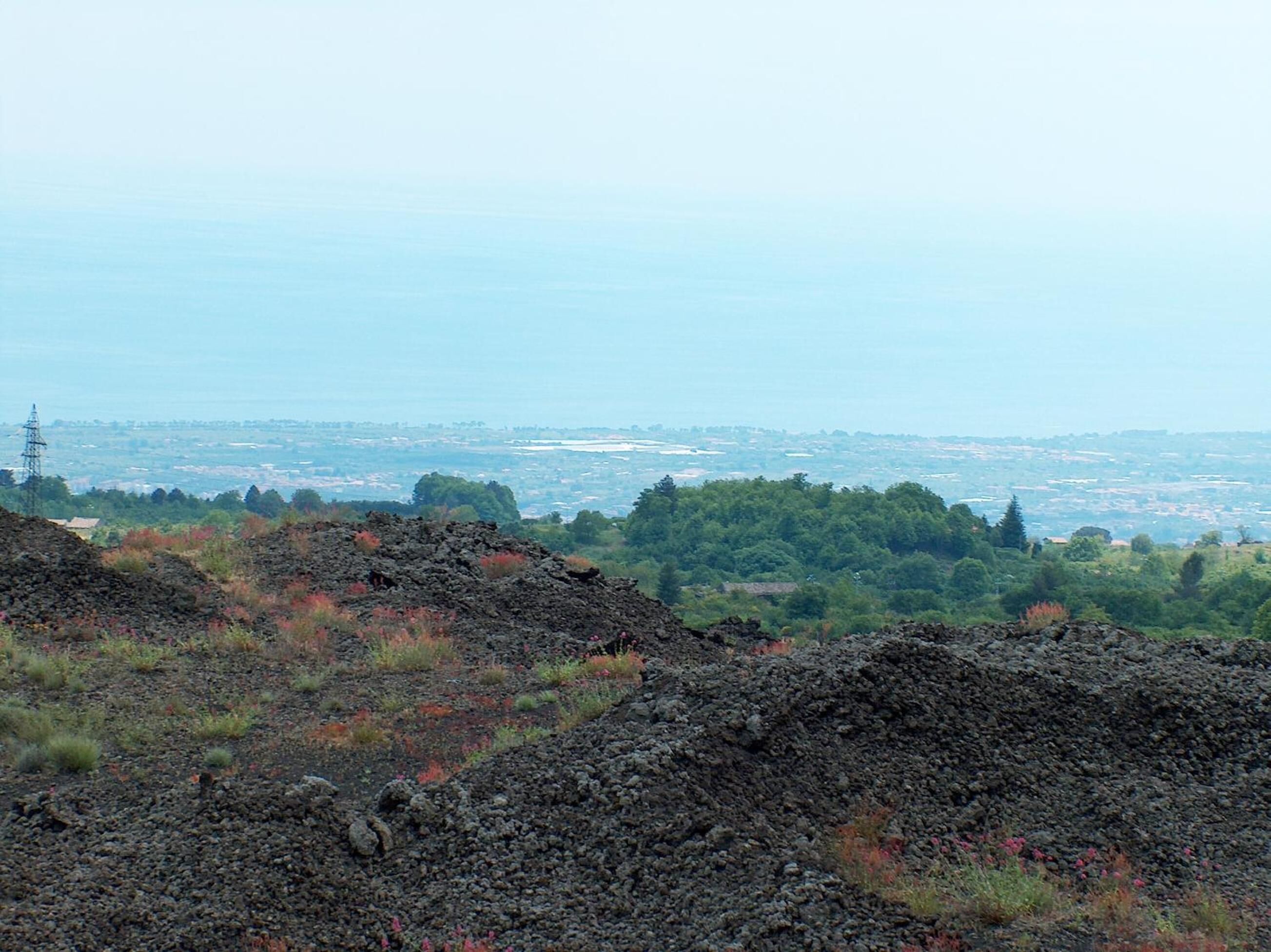 A volcanic landscape with a distant view of a city.
