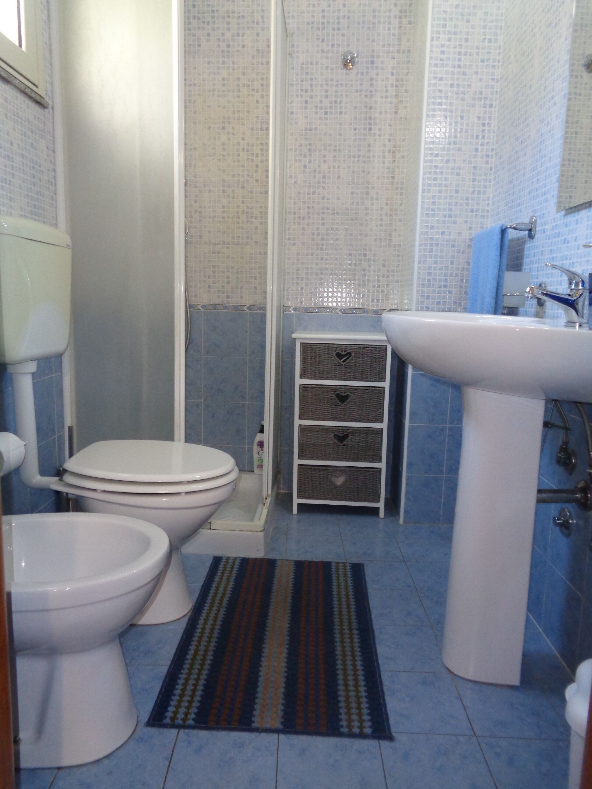 A bathroom with a toilet, bidet, and sink.