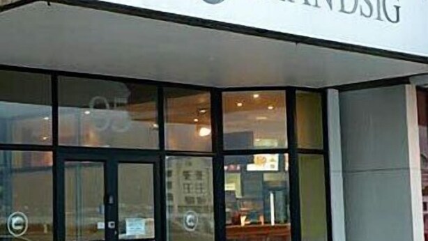A storefront with a sign that reads "STRANDSIG".