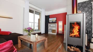 Una sala de estar moderna con chimenea, muebles de madera y televisor.