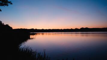 A calm lake at dusk with a clear sky.