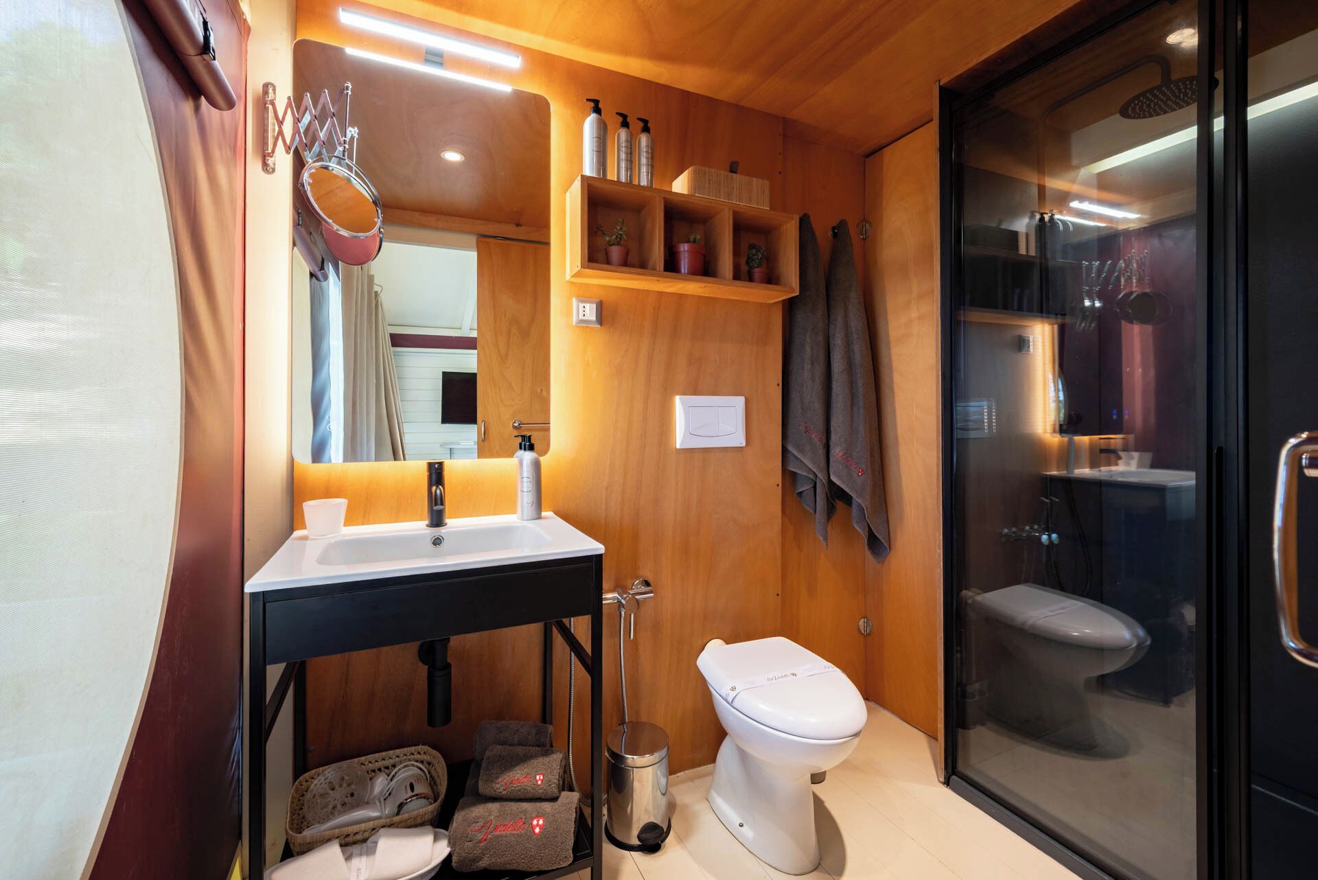 Un baño pequeño con lavamanos, inodoro y zona de ducha.