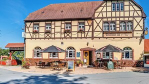 Een traditioneel vakwerkhuis met terras en een bord dat aangeeft dat het een restaurant is.