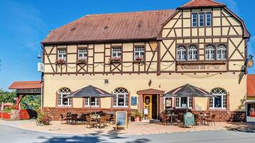 Traditional half-timbered building with a steeply pitched roof and flower-adorned windows.