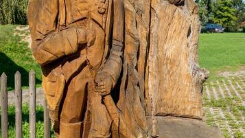 Una escultura de madera de una figura histórica en un parque.