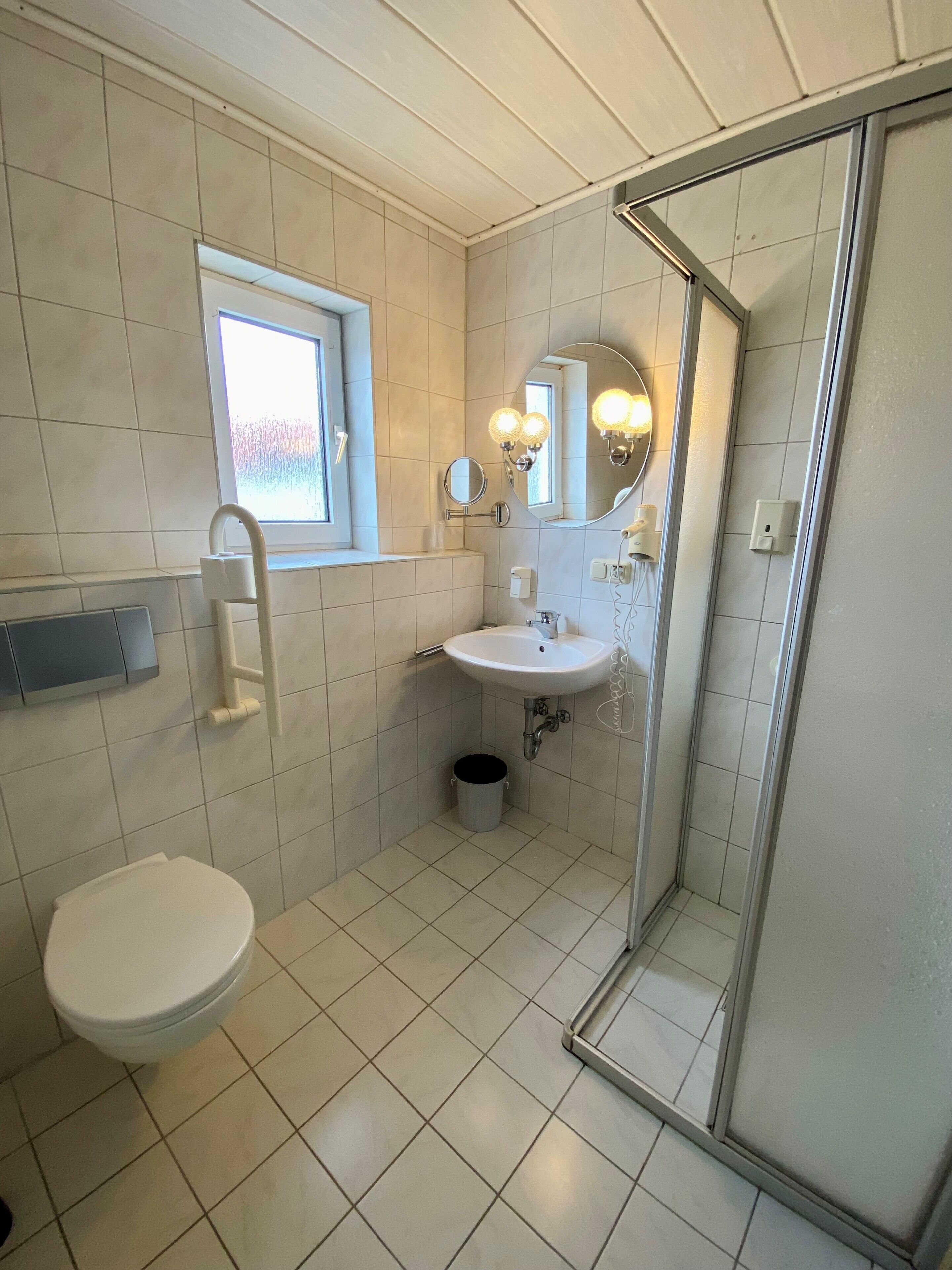 A bathroom with a toilet, sink, and shower.