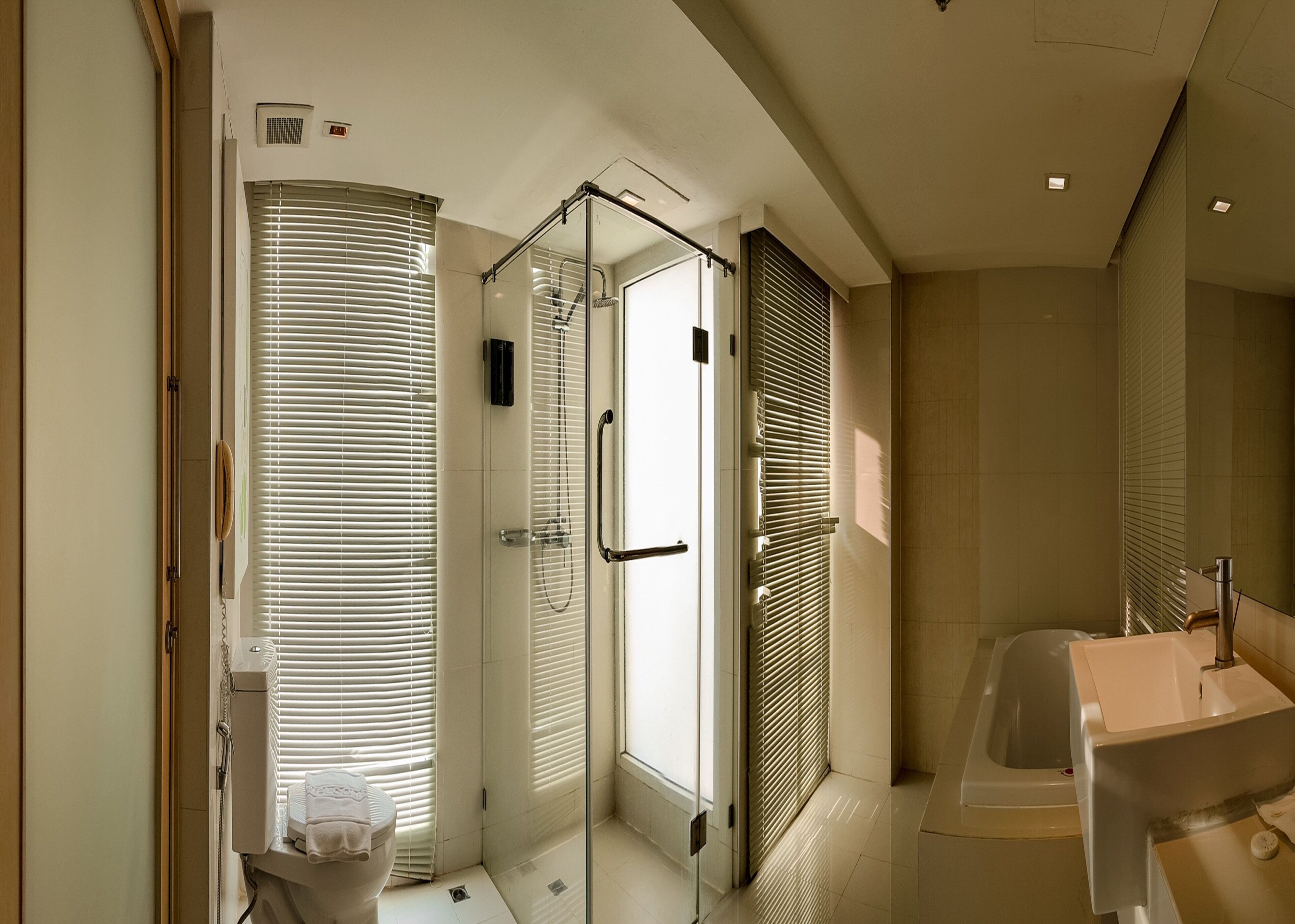Un baño moderno con cabina de ducha de vidrio, inodoro y lavamanos.