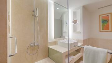 A modern bathroom with a glass-enclosed shower, a white sink, and a large mirror.