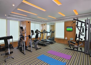 A gym with treadmills, elliptical machines, and weight equipment.