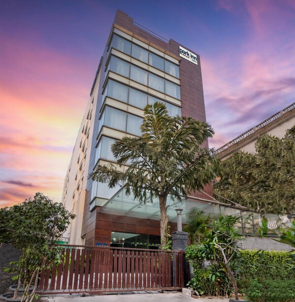 A multi-story hotel with a prominent 'Park Inn' sign, featuring a modern architectural design with large windows and a flat roof.