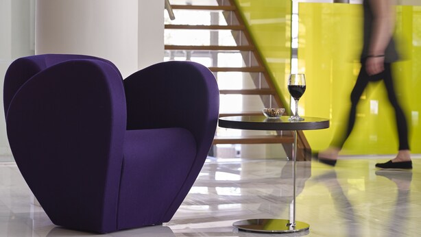 A purple heart-shaped chair, a small table with a wine glass, and a staircase in the background. - Kyma Suites Beach Hotel (Rethymno)