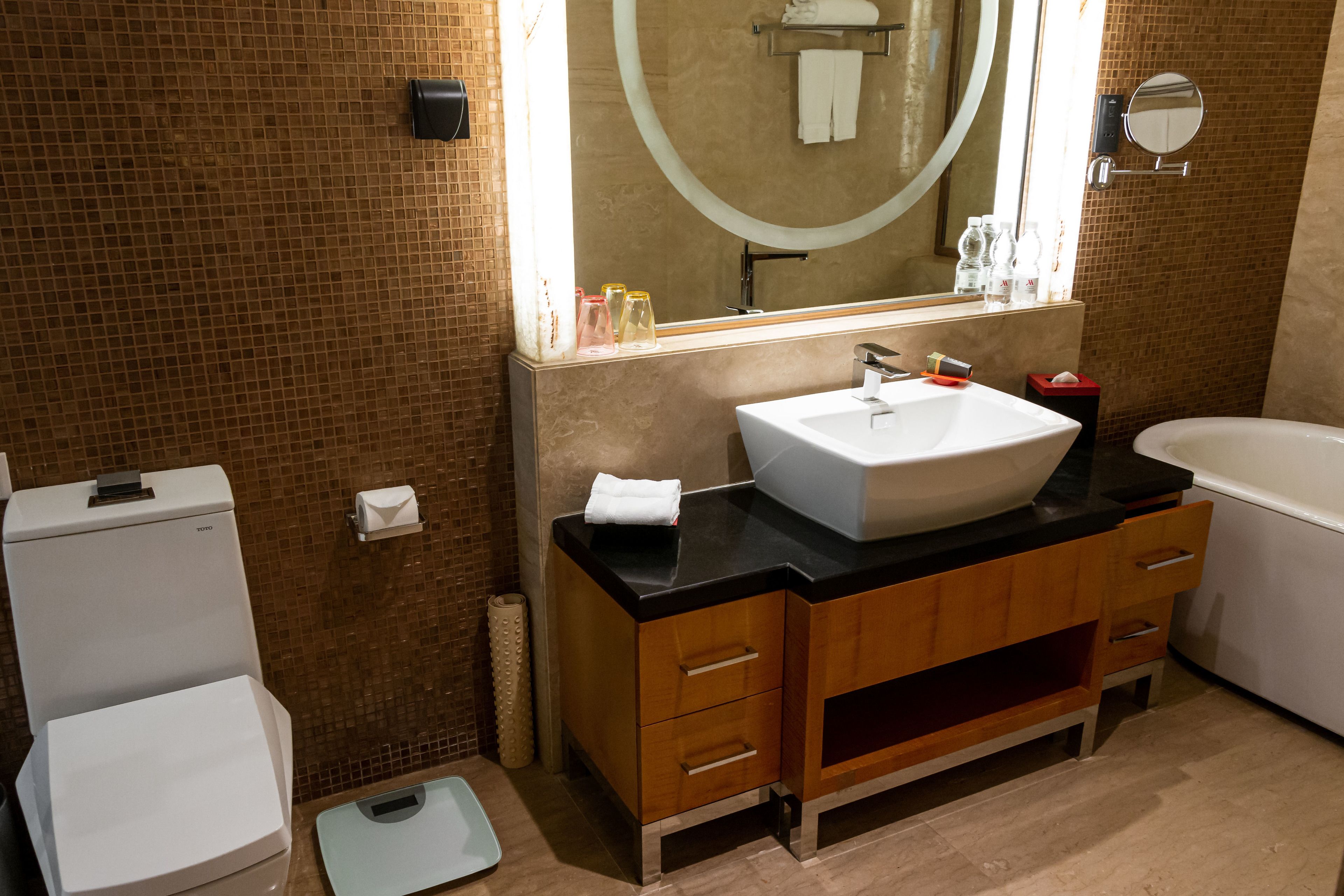 Une salle de bain moderne avec un lavabo blanc, un meuble-lavabo en bois et un grand miroir.