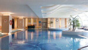 An indoor swimming pool with clear water, a lifebuoy, and a clock on the wall. - Suzhou Marriott Hotel (Suzhou)