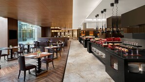 A modern restaurant with wooden flooring, a buffet area, and a seating area with tables and chairs. - Suzhou Marriott Hotel (Suzhou)
