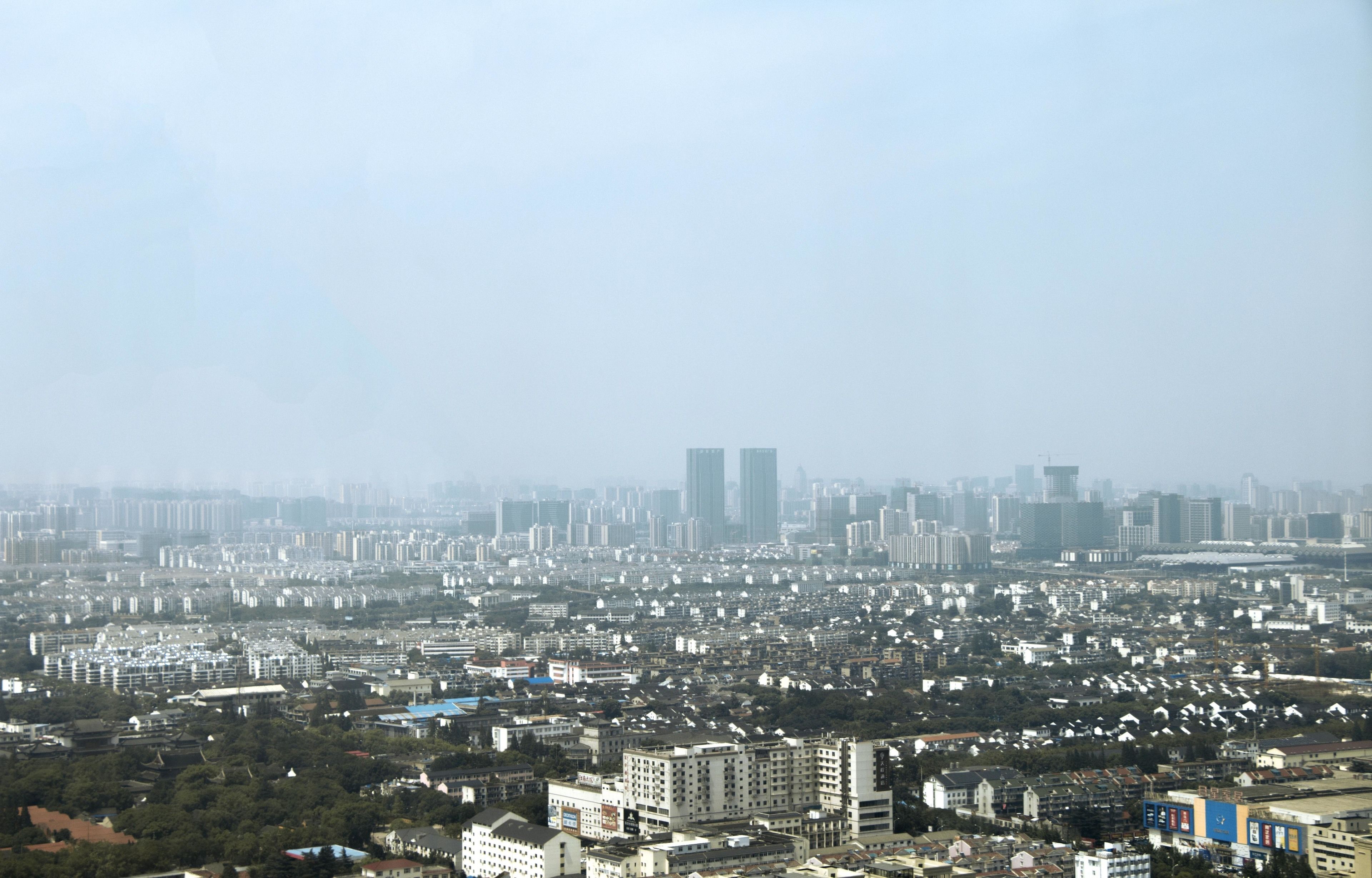 A cityscape with numerous buildings, including high-rise structures and residential areas.