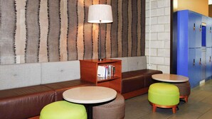Un'area salotto con un divano, due poggiapiedi, un tavolino e una lampada.