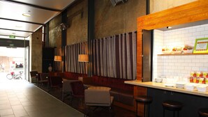 Un ristorante con zona bar, posti a sedere e vista sulla strada.