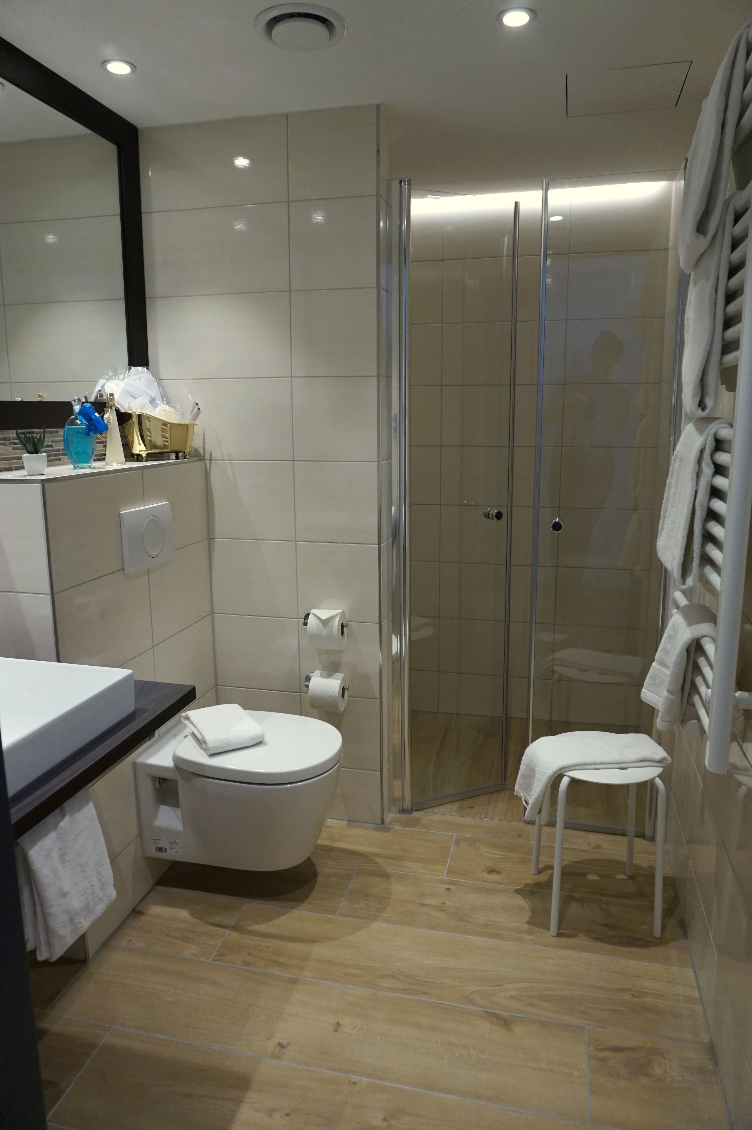 A modern bathroom with a toilet, bidet, and a glass-enclosed shower.