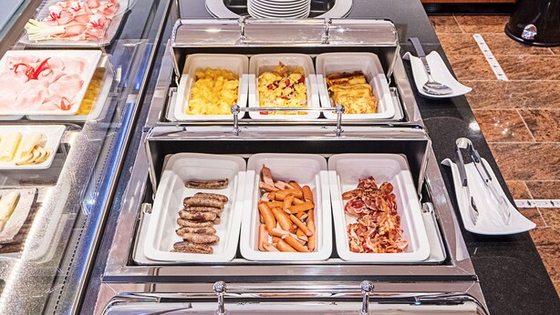 Ein reichhaltiges Buffet mit verschiedenen Speisen, darunter Fleisch, Gemüse und Eier.