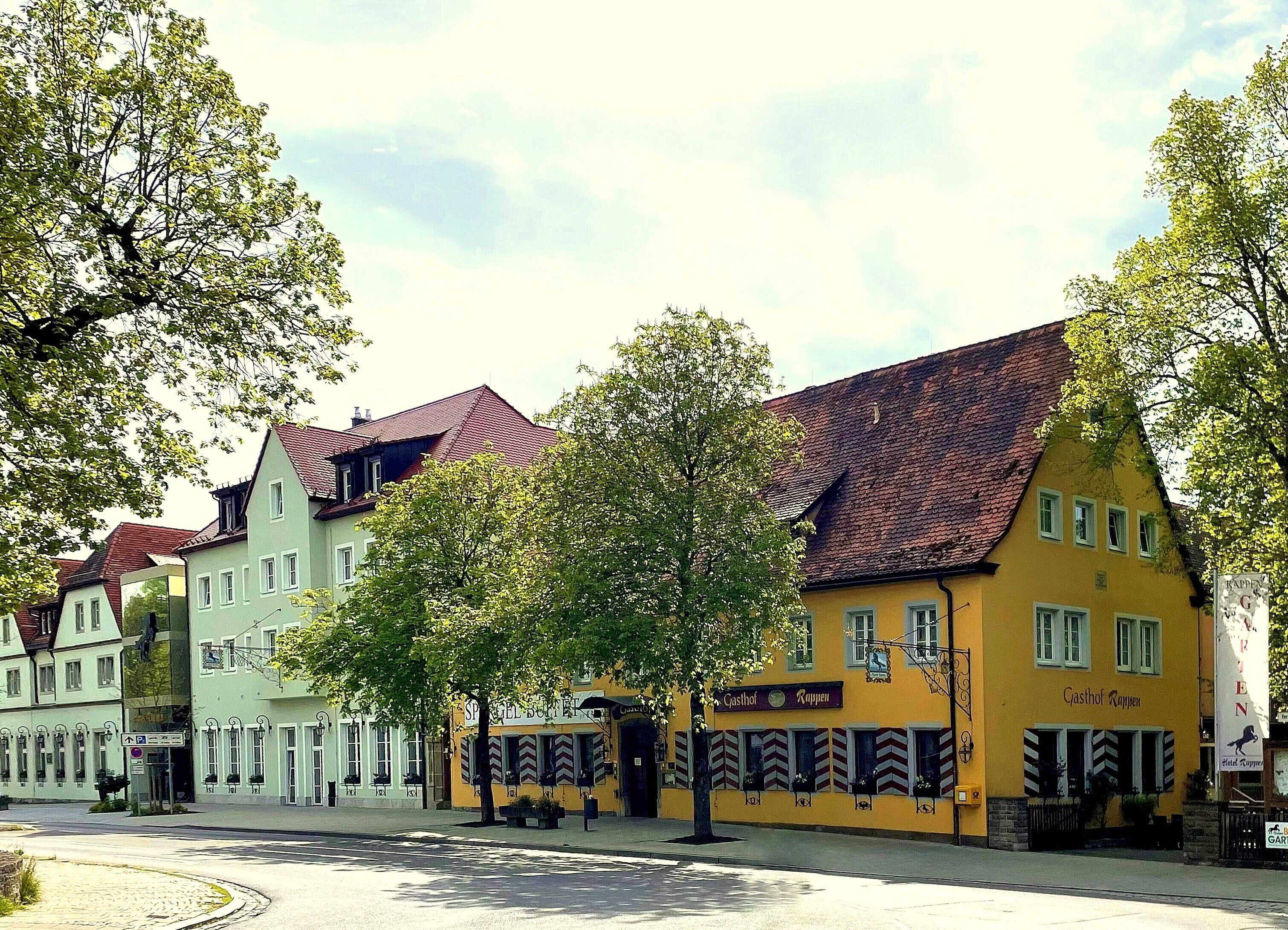 A row of traditional European buildings with a central yellow building labeled "Gasthof Rappen."