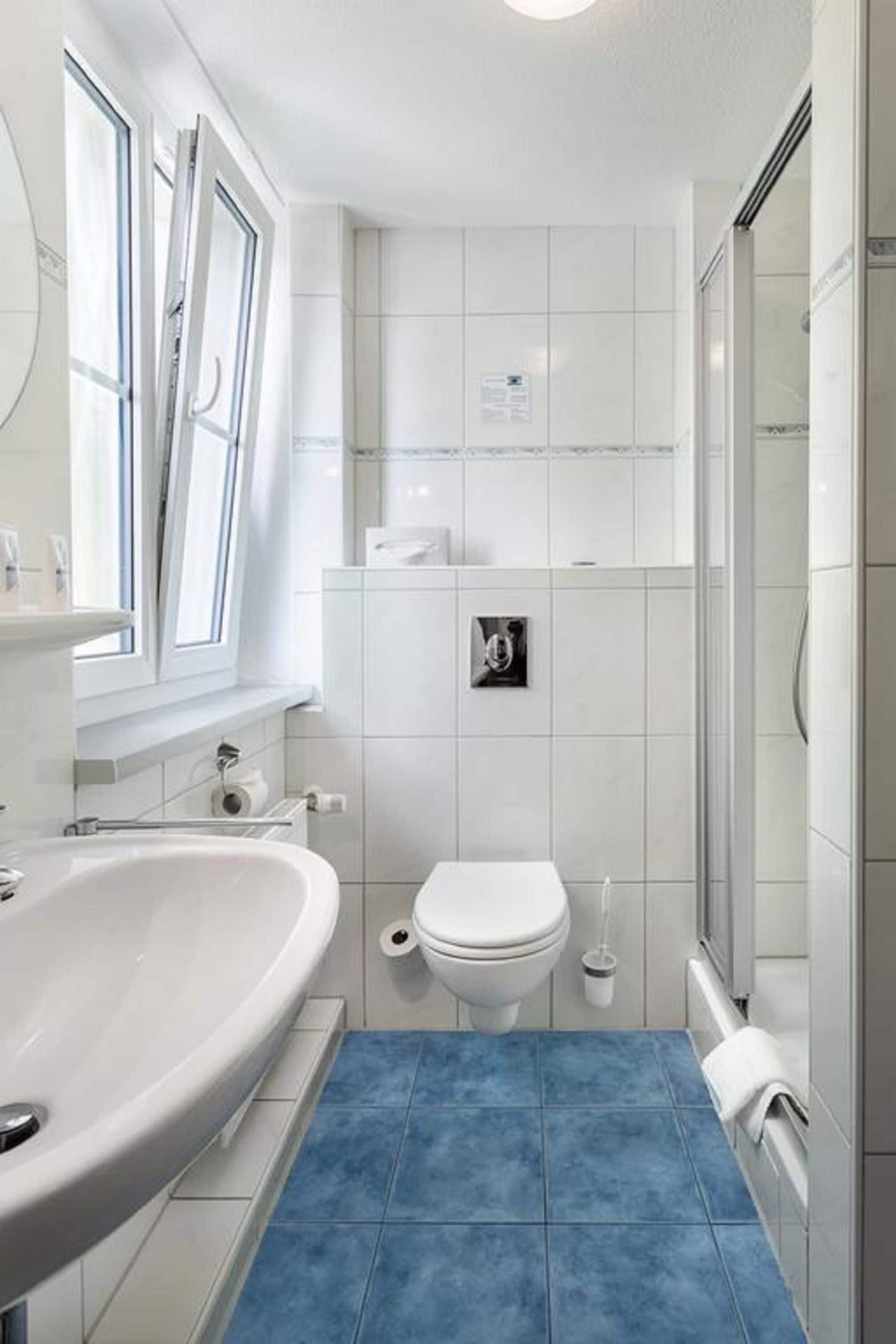 Ein Badezimmer mit großem Waschbecken, Toilette und Dusche.