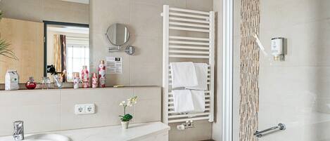 Une salle de bain moderne avec un lavabo blanc, un miroir et une douche à parois de verre.