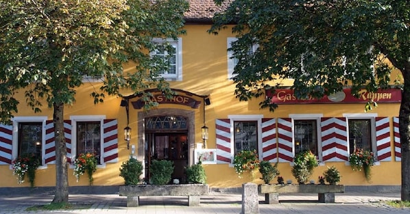 A yellow building with a sign reading "Gasthof Rappen" and a red and white striped awning. - Hotel Rappen Rothenburg ob der Tauber (Rothenburg ob der Tauber)