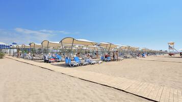 På stranden, solsenger, parasoller og strandhåndklær