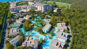 An aerial view of a resort with a central swimming pool, multiple buildings, and a beachfront. - Sueno Hotels Beach Side (Manavgat)