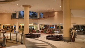 A spacious lobby with high ceilings, multiple seating areas, and a central bar. - Sueno Hotels Beach Side (Manavgat)