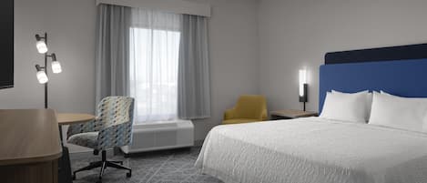 Ett hotellrum med en säng, ett skrivbord, en stol och ett fönster med gardiner.