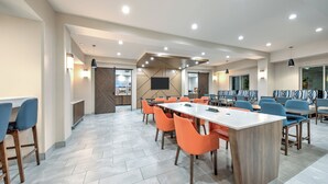 A modern meeting room with a long table, orange chairs, and a wooden accent wall. - Holiday Inn Express Hotel & Suites DALLAS WEST by IHG (Dallas)
