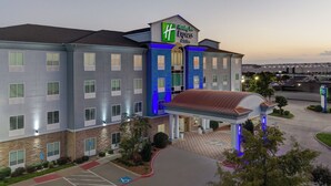 A Holiday Inn Express building with a parking lot, handicap-accessible spaces, and a covered entrance. - Holiday Inn Express Hotel & Suites DALLAS WEST by IHG (Dallas)