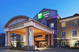 Edificio de Holiday Inn Express & Suites con entrada cubierta y fachada de piedra.