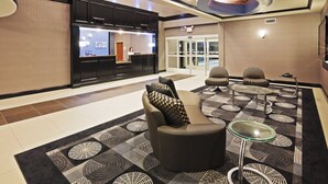 A lobby with a reception desk, seating area, and a patterned carpet. - Holiday Inn Express Hotel & Suites JACKSONVILLE by IHG (Jacksonville)