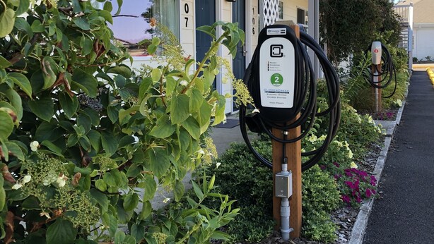 A building with a balcony, a number 107 sign, and a charging station for electric vehicles. - Super 8 by Wyndham Florence OR (Florence)