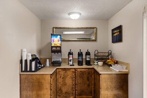 A kitchenette with a coffee machine, a juice dispenser, and a water dispenser.