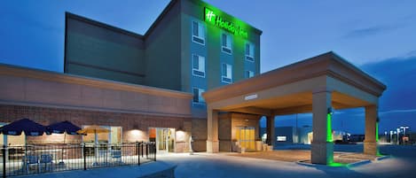 A Holiday Inn Express with a covered entrance and outdoor seating area.
