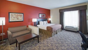 A hotel room with a bed, a sofa, a desk, and a chair. - Holiday Inn Lincoln Southwest by IHG (Lincoln)