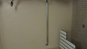 A bathroom with a bathtub, a showerhead, and a towel rack.