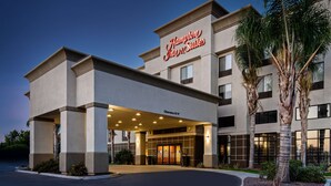 A Hampton Inn & Suites with a modern facade, a covered entrance, and palm trees. - Hampton Inn & Suites Bakersfield/Hwy 58, CA (Bakersfield)