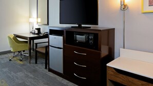 A hotel room with a desk, a television, a refrigerator, and a chair. - Hampton Inn & Suites Bakersfield/Hwy 58, CA (Bakersfield)