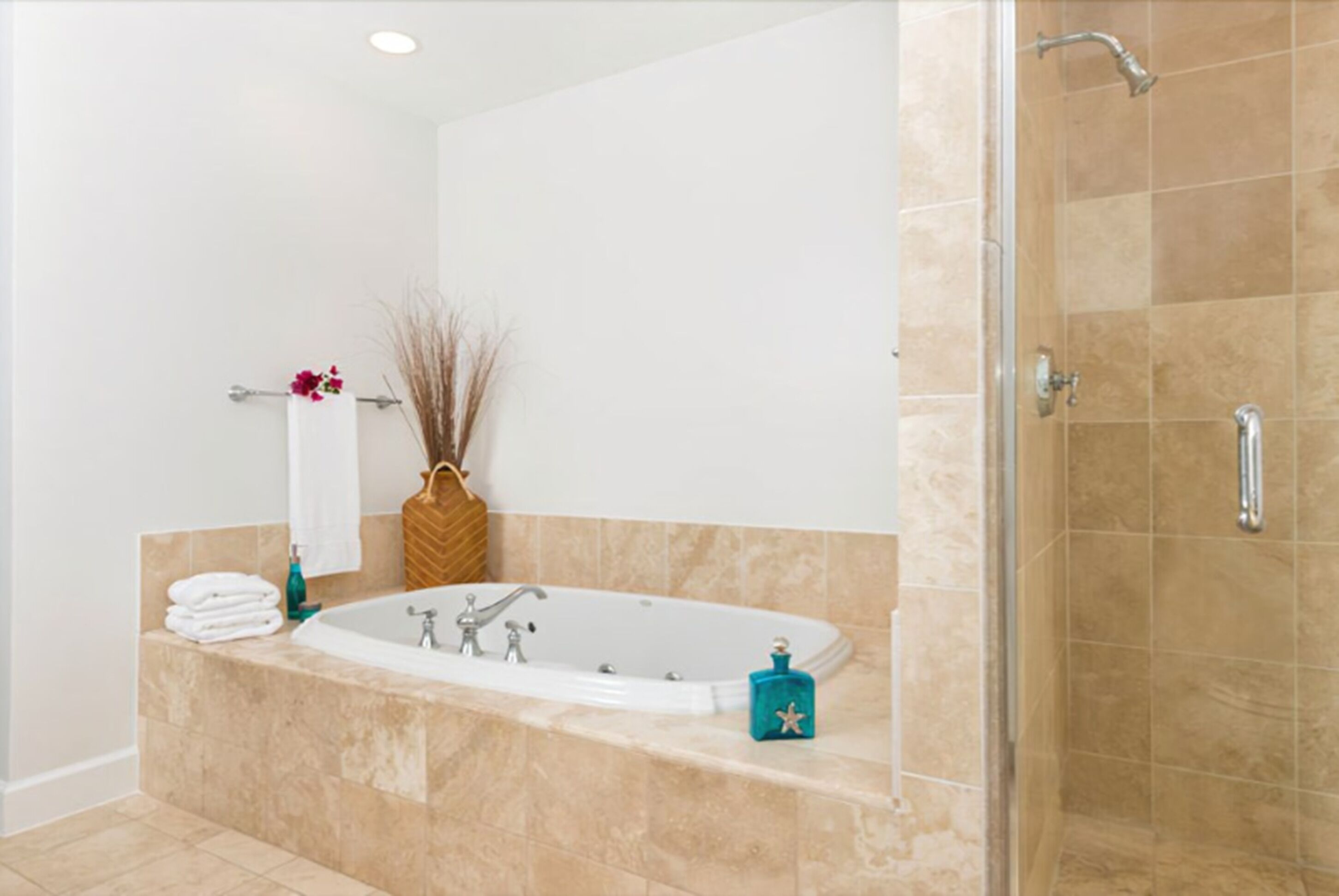 A modern bathroom with a freestanding bathtub, a shower area, and a towel rack with folded towels.