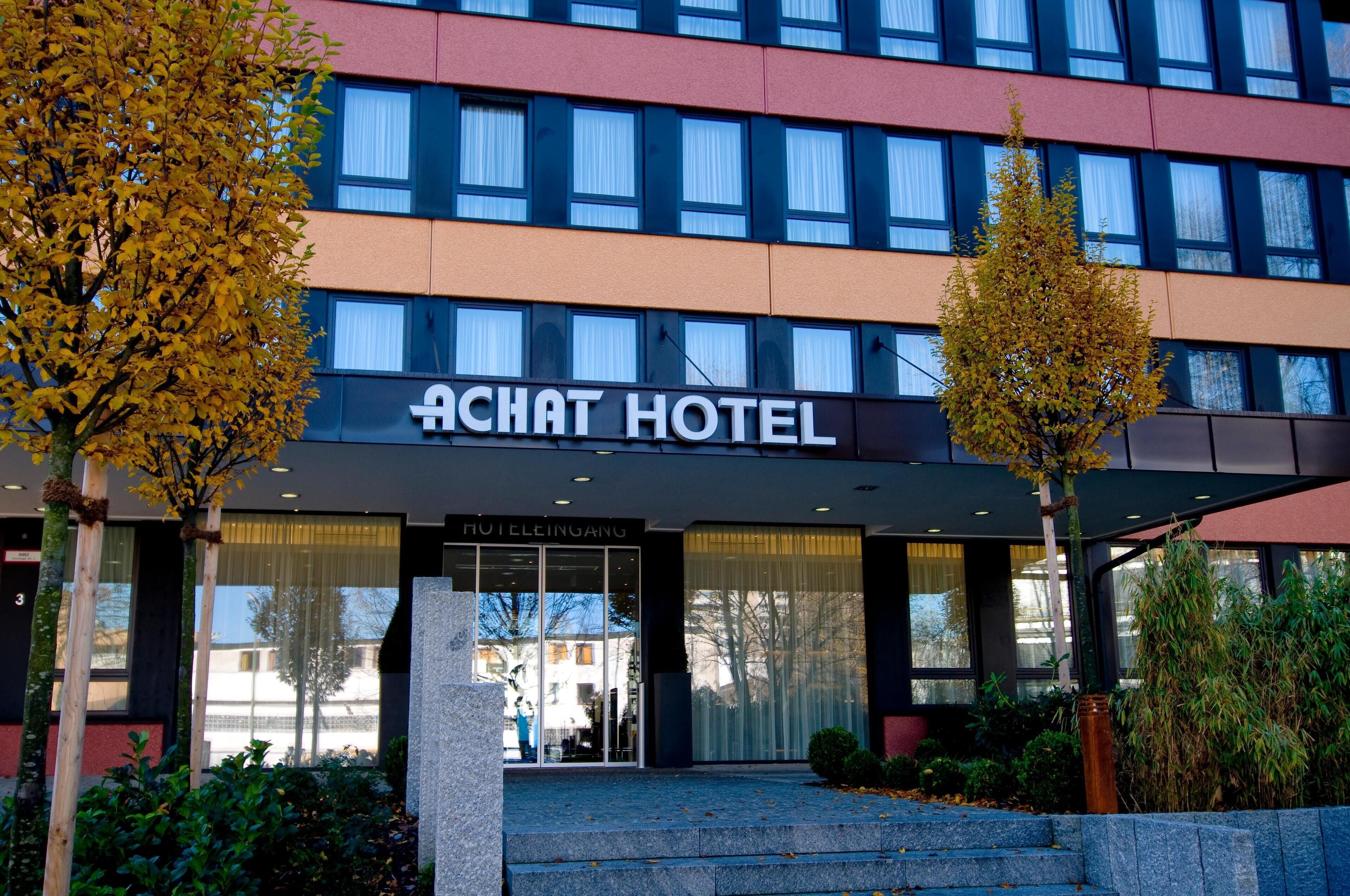 Ein Hotel Eingang mit einem Schild, auf dem 'ACHAT HOTEL HOTELLEINGANG' steht.