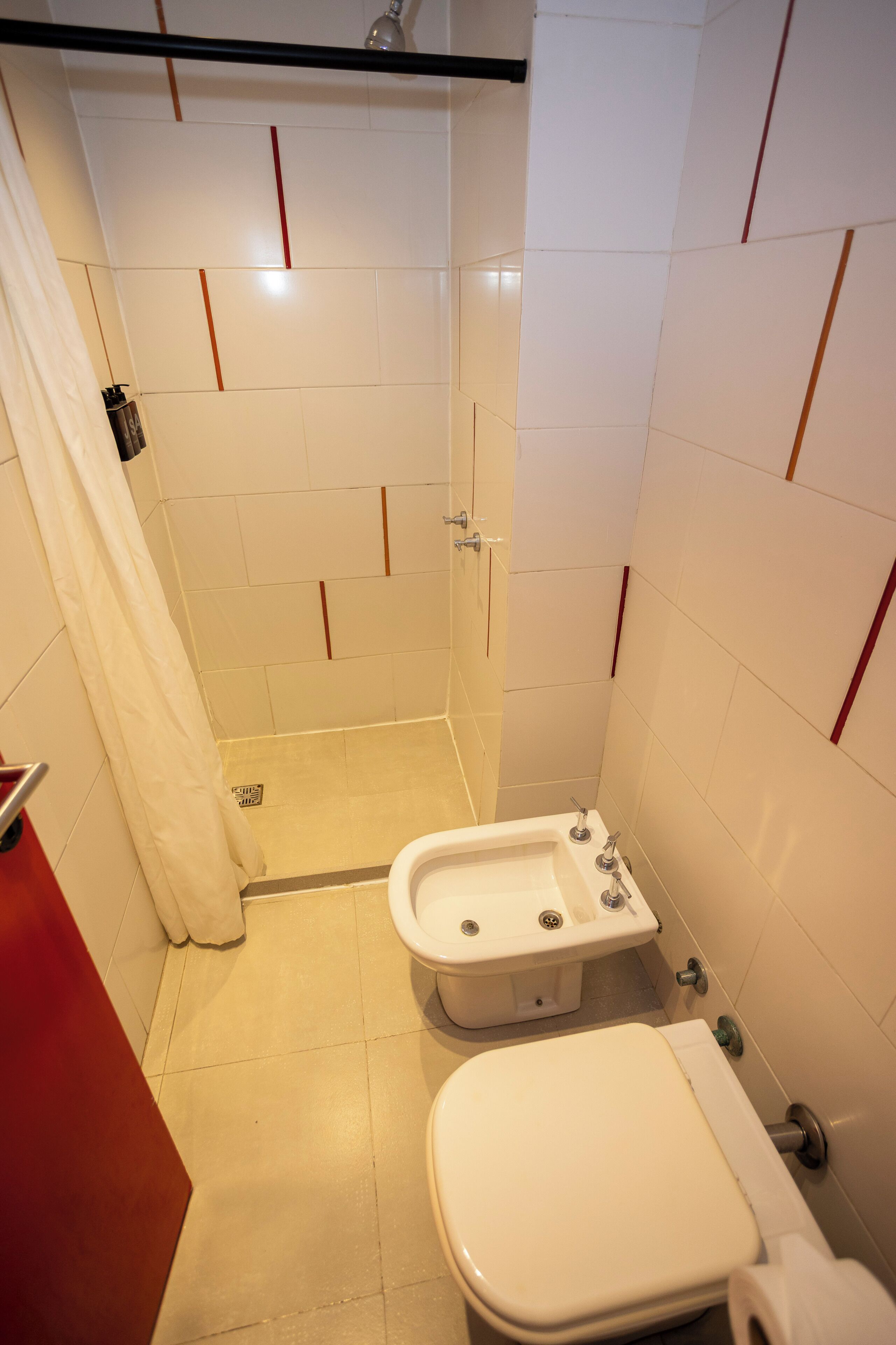 Un baño con ducha, inodoro y bidé.