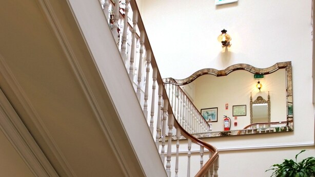 A grand staircase with a wooden handrail and red carpeted steps. - Hotel Miradaire Porto (Porto)
