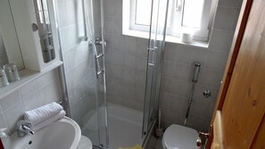 A bathroom with a glass-enclosed shower, a toilet, and a sink. - Hotel Restaurant Linde (Otterstadt)