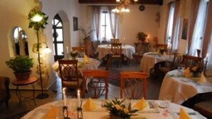 A dining area with round tables, chairs, and candle centerpieces. - Hotel Restaurant Linde (Otterstadt)