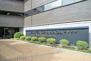 Hotel Granada features a modern architectural design with a prominent entrance and glass facade.